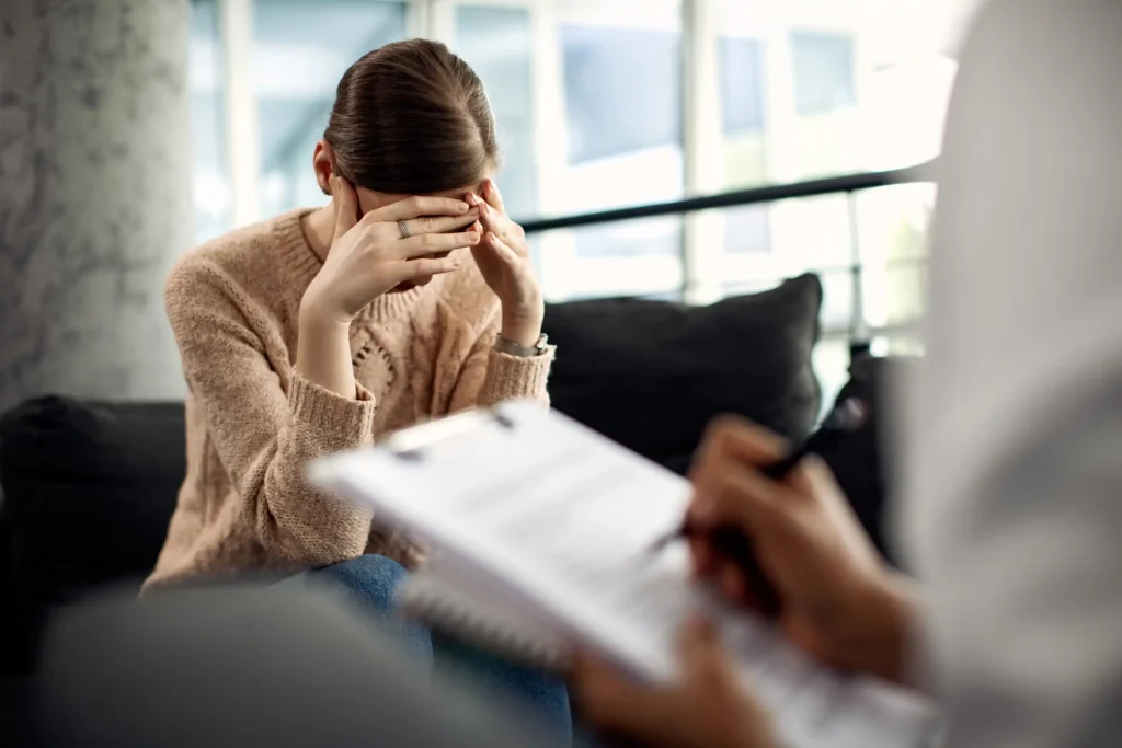 Woman holding head during therapy session